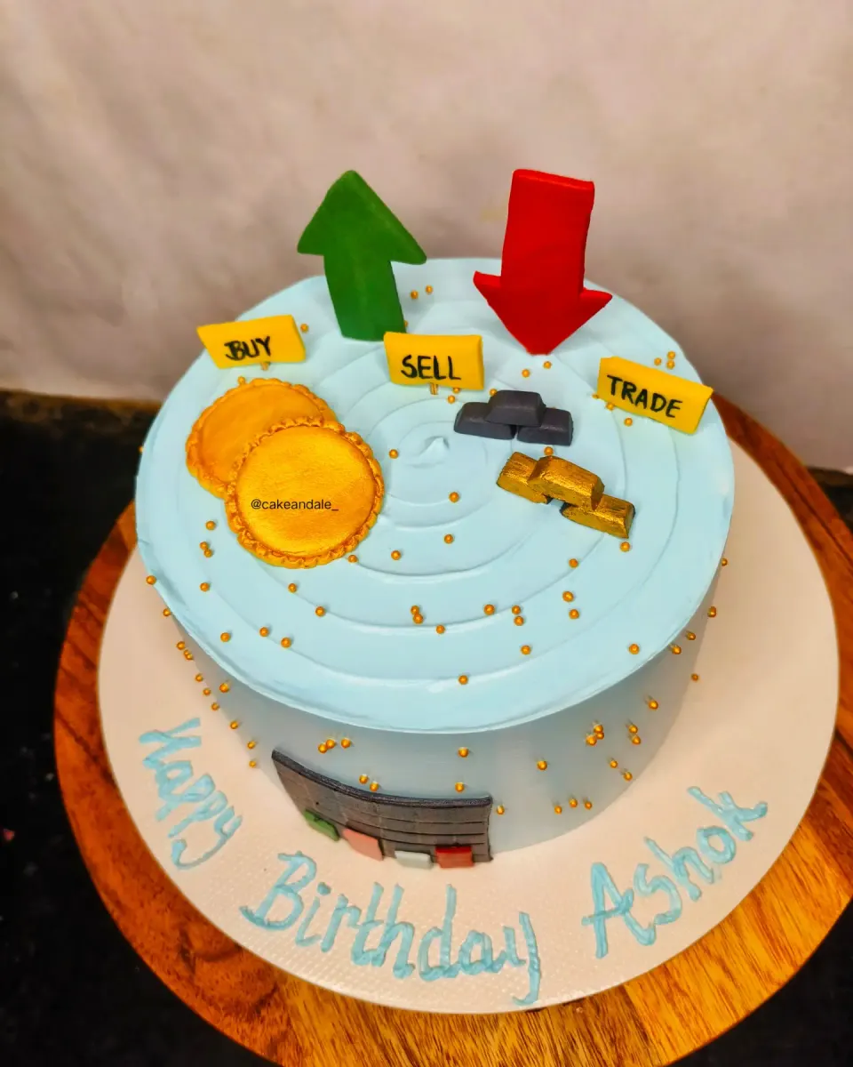 Top view of a stock market themed birthday cake with gold coins and bars
