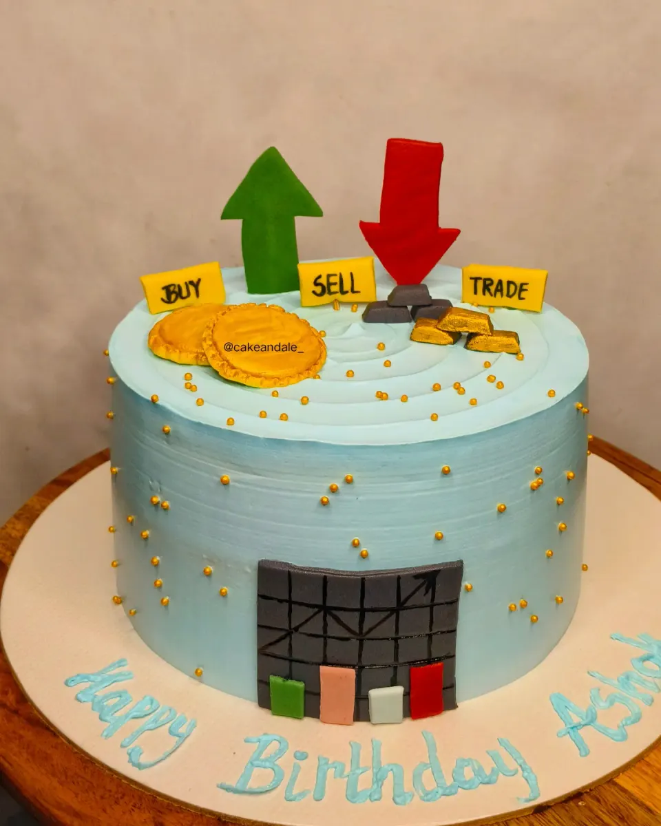 Blue birthday cake for a stock trader with buy, sell, trade signs, gold coins and market arrows