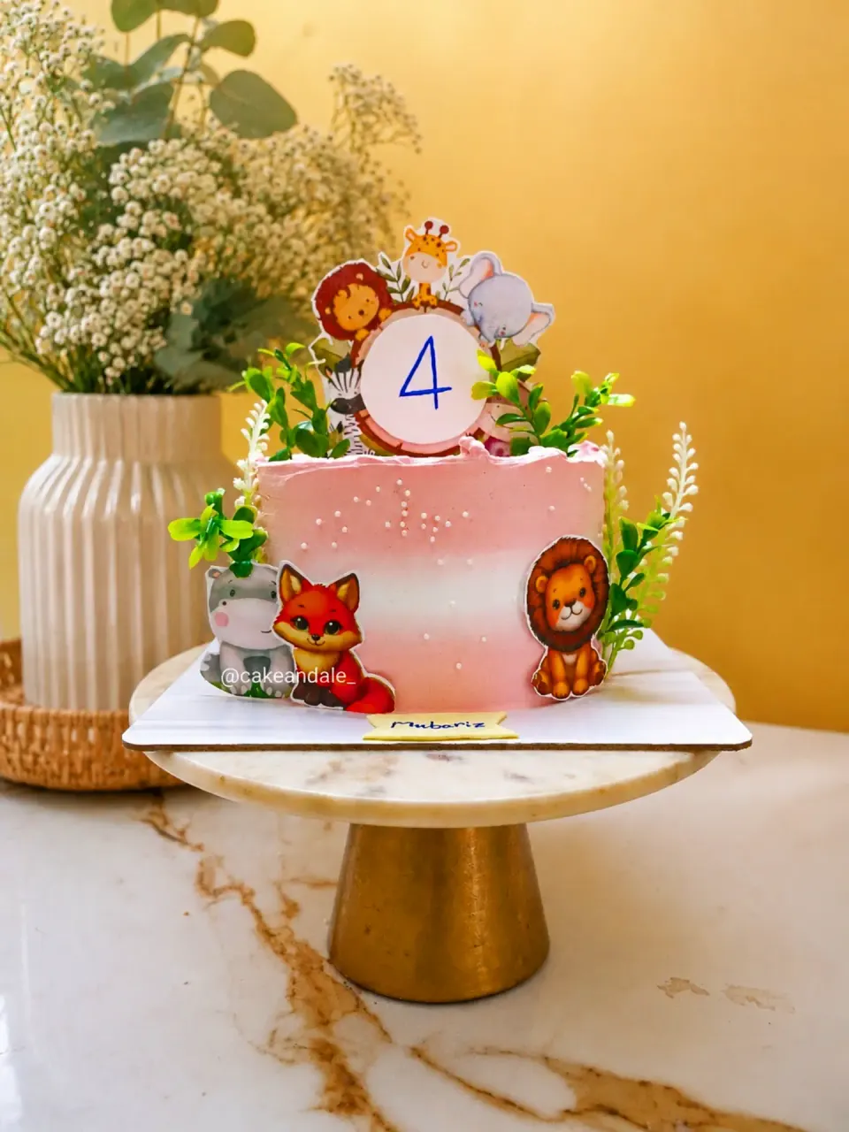 Pink ombre fourth birthday cake with lion, fox, giraffe and elephant toppers and greenery